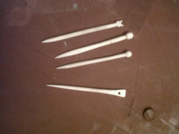 Three bone pins and one bone needle